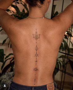 the back of a woman's body with tattoos on her upper and lower back