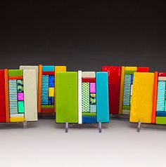 a row of brightly colored books sitting next to each other on metal stands with wheels