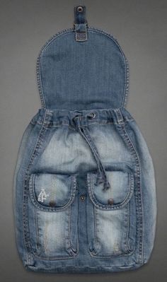 an old pair of jeans is hanging on the wall in front of a gray background