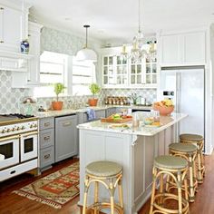 a kitchen with an island and stools next to the stove top oven in it