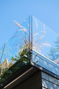 a glass box on top of a building with trees in the backgroung