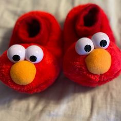 a pair of red slippers with googly eyes