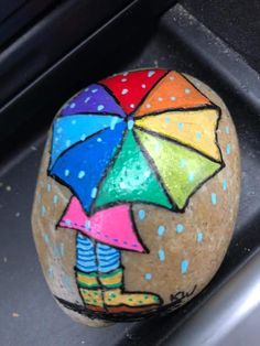 a painted rock with an umbrella on it