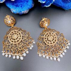 Oversized statement earrings in sterling silver with 22K gold plating. Set with freshwater pearls, it has a clip at the back and a threaded screw. The hanging drops and beads are freshwater pearls. Weight : 45 GMs Dimensions : 4 x 2.5 inches Pearl Embellished Earrings For Festive Occasions, Festive Gold Pearl Drop Earrings, Festive Gold Plated Pearl Earrings For Pierced Ears, Gold Pearl Drop Danglers, Gold Chandbali Pearl Earrings For Party, Gold Elegant Pearl Earrings, Traditional Pearl Embellished Earrings, Gold-plated Pearl Drop Danglers, Gold Pearl Drop Chandbali Earrings