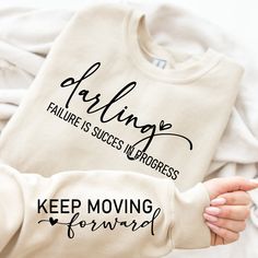 someone is holding up a t - shirt that says, helping failure is success in progress keep moving forward