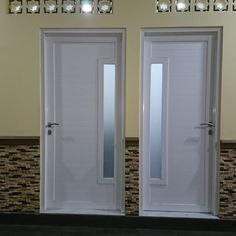 two white double doors in front of a tiled wall