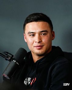 a man sitting in front of a microphone and looking at the camera with an intense look on his face