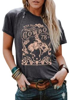 a woman wearing a cowboy t - shirt with her hands in her pockets and looking at the camera