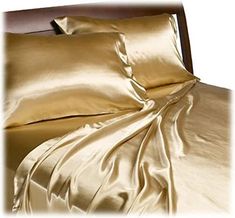 an image of a bed with gold sheets and pillow cases on the bottom half of it