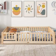 a baby's room with two paintings on the wall and a crib in front