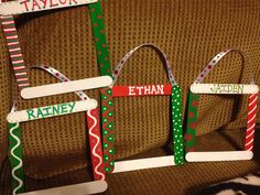 three christmas themed nameplates are on the back of a couch with a cat laying next to them