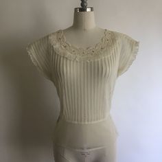 "Gorgeous sheer 1940's short sleeve nylon blouse with lace collar and rhinestones has pretty cap sleeves with a layer of pleated ruffle. Blouse zips up on the side and is in excellent vintage condition. Made by Debcraft and possibly one of the nicest nylon blouses I have come across! Shoulders 15\" Chest up to 36\" Waist 28\" Length from back of neck to hem 18\" Vintage garments have been previously worn and lovingly cared for, they may however have a blemish or two. Here at MadelonVintage, I tr Fitted Blouse With Lace Trim For Vintage Fashion, Fitted Vintage Lace Top For Daywear, Fitted Lace Trim Blouse For Vintage Fashion, Vintage Sheer Tops For Wedding, Vintage Fitted Lace Top For Daywear, Classic Short Sleeve Tops For Vintage Fashion, Classic Vintage Short Sleeve Tops, Fitted Vintage Top With Lace Work, Vintage Fitted Lace Top For Spring