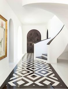 an entry way with black and white tiles on the floor, and a door in the center