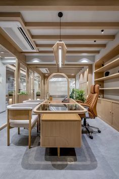 an office space with desks, chairs and shelves on the walls is lit by recessed lights