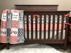 a baby crib with pink and gray bedding on top of white fluffy rugs