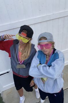 two young people wearing sunglasses and one is pointing at something