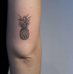 a small pineapple tattoo on the arm