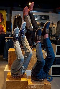 two people laying on top of wooden blocks in a clothing store with their feet up