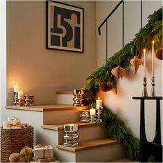 candles are lit on the stairs in front of christmas decorations