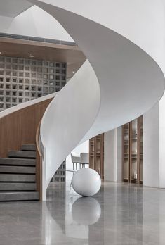 a large white spiral staircase in a modern building