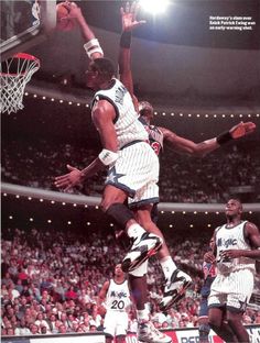 a basketball player jumping up to dunk the ball in front of two other players