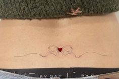 a woman's stomach with a small red heart on her left side ribcage