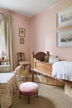 a baby's room with pink walls and wicker furniture in the foreground