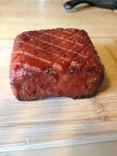 a piece of meat sitting on top of a wooden cutting board