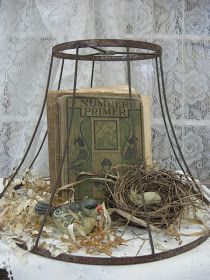 an old book is sitting in a cage with some birds nesting on top of it