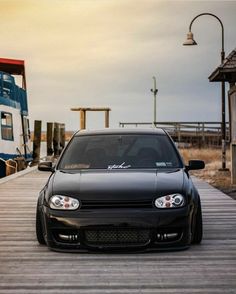 a black car parked on top of a wooden dock