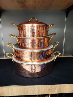 three copper pots stacked on top of each other