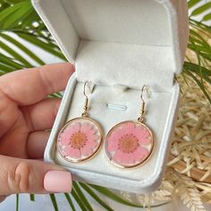 𝐑𝐄𝐀𝐋, 𝐏𝐑𝐄𝐒𝐒𝐄𝐃 𝐅𝐋𝐎𝐖𝐄𝐑𝐒 ✨    These earrings are made with real pressed flowers, perfectly preserved within resin. Their color and beauty will live on forever!       This is the perfect, 𝐭𝐡𝐨𝐮𝐠𝐡𝐭𝐟𝐮𝐥 gift for any plant lover, flower enthusiast, or unique jewelry girlie in your life.          𝐅𝐞𝐚𝐭𝐮𝐫𝐞𝐬: Real flowers preserved in crystal-clear resin.    Gold-plated hooks for a luxurious and durable finish.    Each pair is unique, showcasing the natural beauty of daisy blooms.       𝐒𝐩𝐞𝐜𝐢𝐟𝐢𝐜𝐚𝐭𝐢𝐨𝐧𝐬: Material: Real daisy flowers, resin, gold-plated hooks.    Size: Approximately 1 inch in length (including hook).    Closure: Gold-plated hooks for pierced ears.          𝐖𝐇𝐘 𝐘𝐎𝐔 𝐒𝐇𝐎𝐔𝐋𝐃 𝐂𝐇𝐎𝐎𝐒𝐄 𝐌𝐎𝐎𝐍𝐒𝐓𝐑𝐔𝐂𝐊 🌝    This is a one-wom Flowers Resin, Daisy Earrings, Daisy Flowers, Clay Design, Pink Daisy, Flowers Pink, Clear Resin, Real Flowers, Plant Lover