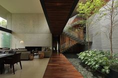 a living room filled with furniture next to a wooden floor covered in lots of plants