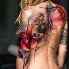 the back of a woman's body with tattoos on her chest and flowers painted on it