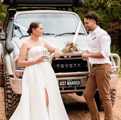 a man standing next to a woman in front of a truck