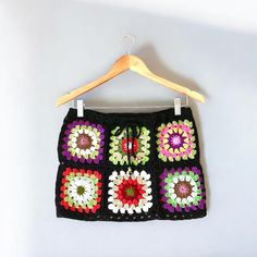 a crocheted skirt hanging on a wooden hanger