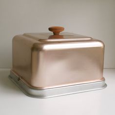 a shiny metal container with a wooden top