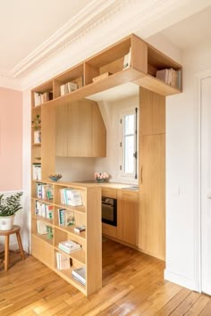 a kitchen with pink walls and wooden floors