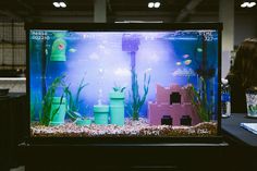 a fish tank filled with water and plants on top of a table next to other items