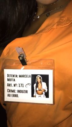 a person wearing an orange jacket with a name tag on it and a badge attached to the back of their shirt