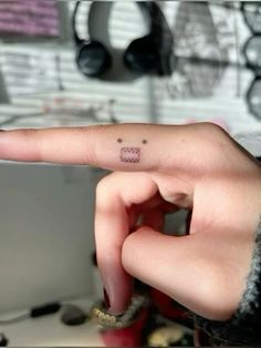 a person with a small tattoo on their finger pointing to the left side of her hand