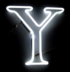 a neon sign that is lit up in the shape of a letter y on a black background