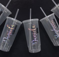 four plastic cups with the words charlotte on them are lined up against each other and have their lids down