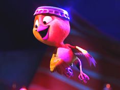 an animated bird flying through the air with a hat on its head and wings, in front of a stage