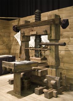 an old fashioned machine sitting on top of a wooden floor next to a couch and table