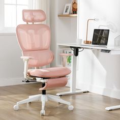 a pink office chair sitting on top of a wooden floor next to a white desk