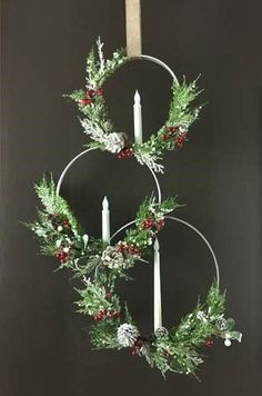 two christmas wreaths with candles hanging from them