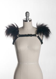 This chest harness with faux fur shoulder detail adds instant gothic drama and impact to any outfit. This piece works especially well with dresses and flowing tops that don't have a defined waistline, or paired with a corset. Buckles in front across chest. Silver toned nickel-plated steel hardware. Shown in black leather. Also available in PVC. All colors have black faux fur except white PVC, which has white faux fur.All pieces are MADE TO ORDER, standard sizes XS-4XL. If your measurements fall Fitted Gothic Harness For Cosplay, Fitted Punk Harness For Alternative Fashion, Gothic Party Harness With Straps, Gothic Fitted Harness For Party, Edgy Fitted Harness For Alternative Fashion, Punk Style Harness For Night Out, Shoulder Harness, Chest Harness, Black Pvc