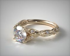 an engagement ring with a twisted band and a round diamond center stone on the side