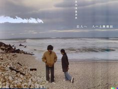 two people are standing on the beach looking at the water and clouds in the sky